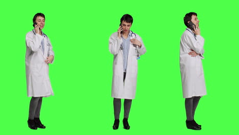 Woman-doctor-talking-on-smartphone-call-against-greenscreen-backdrop